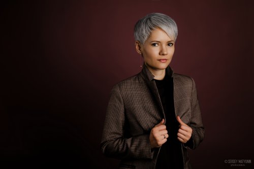 Стильный деловой портрет женщины с короткой стрижкой для бизнес съемки на темном фоне