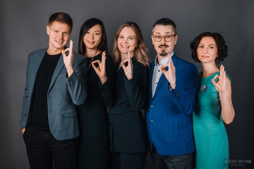 Корпоративная бизнес-съемка успешной команды коллег в деловом стиле на сером фоне